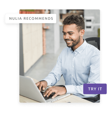 A man smiling while using his laptop